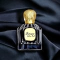Maison Alhambra Baroque Satin Oud 100ml — A dark glass perfume bottle with a gold patterned cap rests on black satin fabric. | Maison Alhambra Baroque Satin Oud 100ml — Botol minyak wangi kaca gelap dengan penutup corak emas terletak di atas fabrik satin hitam.