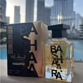 Ard Al Zaafaran Bashaara Eau De Parfum 100ml by Ard Al Zaafaran — Kotak wangian hitam keemasan dan botol kaca jernih dengan penutup hitam, latar belakang bangunan moden
