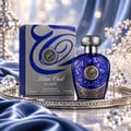 Lattafa Blue Oud Elixir by Lattafa 100ml EDP Unisex — A blue glass perfume bottle and its silver box sit on a decorative silver tray with blue satin fabric and crystal accents.