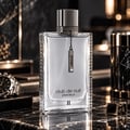 Armaf Club de Nuit Precieux II — A clear glass perfume bottle with a metallic cap and a hanging tag with 'ARMAF' and a diamond accent, set on a marble surface with a watch and cufflinks.