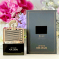 Rave Pure Desire Gold by Rave 100ml EDP — A gold-accented perfume bottle with a perforated gold cage and a black base, next to its black and gold box, with a blurred floral background.
