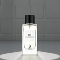 Maison Alhambra L'Impressio Pour Femme — Clear glass perfume bottle with a white label featuring black text and a deer silhouette, topped with a black cap, set against a tiled background.