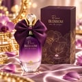 TADangel Fleur Blossom 100ml EDP Women — Purple gradient perfume bottle with a large satin bow and crystal cap, next to its matching box with floral design, on a satin cloth with flower petals.