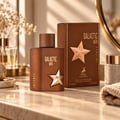 Maison Alhambra Galactic Men Intense by Maison Alhambra 100ml EDP — Brown bottle and box with gold star emblem, displayed on a marble surface with decorative dried flowers and a folded towel.