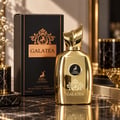 Maison Alhambra Galatea — Gold bottle and black box with gold accents, featuring deer and lion emblems, set on a marble surface with decorative elements.