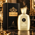 Maison Alhambra Galatea 100ml EDP Unisex — Gold bottle and black box with gold accents, featuring a lion emblem and deer motif, set on a marble surface with blurred golden background.