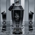 Zimaya Ghali Imperial Eau De Parfum 100ml by Zimaya — Black fluted glass bottle with a silver ornate cap and black tassel, set against a mirrored background with reflections of the bottle. | Zimaya Ghali Imperial Eau De Parfum 100ml by Zimaya — Botol kaca hitam berlekuk dengan penutup perak berhias dan rumbai hitam