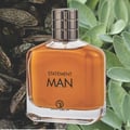 Grandeur Statement Man Eau De Parfum 100ml — A clear glass perfume bottle with amber liquid, a silver textured cap, and black text reading "STATEMENT MAN" and "GRANDEUR" | Grandeur Statement Man Eau De Parfum 100ml — Botol kaca jernih berisi cecair berwarna ambar, penutup bertekstur perak, dan teks hitam bertulis