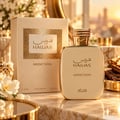 RASASI Hawas Addiction by Rasasi 100ml EDP — Botol dan kotak minyak wangi emas dengan teks Arab dan Inggeris, diletakkan di atas permukaan marmar bersama bunga putih dan perincian emas.