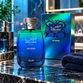 RASASI Hawas Atlantis by Rasasi 100ml EDP — Botol minyak wangi kaca biru dan hijau gradien dengan penutup perak bertekstur, diletakkan di atas meja marmar bersebelahan kotak sepadan dan tuala biru tua berlipat.