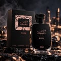 RASASI Hawas Black For Him oleh Rasasi 100ml EDP — Botol dan kotak wangian hitam di atas batu bertekstur dengan latar belakang langit bandar yang kabur pada waktu malam, kesan asap.