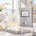 RASASI Hawas Blanche by Rasasi 100ml EDP — White fragrance bottle and silver box displayed on a marble surface with rolled white towels and white orchids.