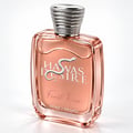 Kenz de Rasasi Hawas Desire First Kiss — Botol minyak wangi kaca jernih berisi cecair rose-gold, dengan lambang ular perak dan penutup perak berukir, di latar belakang putih.