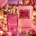 RASASI Hawas Dreams by Rasasi 100ml EDP — Pink glass perfume bottle with gold cap, next to its pink box, set against a romantic bokeh background with fairy lights and rose petals.