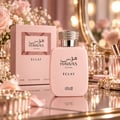 RASASI Hawas Eclat by Rasasi 100ml EDP — Pink perfume bottle and box with floral accents, crystal-embellished cap, and makeup brushes in the background.