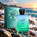 RASASI Hawas For Him La Mer — Kotak hadiah teal dan botol kaca biru-hijau gradien dengan titisan air, diletakkan di atas batu basah di tepi laut semasa matahari terbenam.