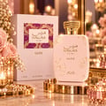 RASASI Hawas Glitz by Rasasi 100ml EDP — Pink bottle with gold glitter accents and ornate gold cap, next to its matching pink box with a patterned insert, surrounded by soft pink roses and lit candles.