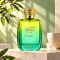RASASI Hawas Verde by Rasasi 100ml EDP — Botol minyak wangi kaca gradien hijau dan kuning dengan penutup bertekstur emas, di latar belakang hijau lembut dengan bayangan daun dan mangkuk batu bertekstur.