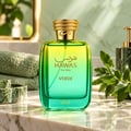 RASASI Hawas Verde by Rasasi 100ml EDP — Botol minyak wangi kaca gradien hijau dan kuning dengan penutup bertekstur emas, diletakkan di atas meja marmar dengan tuala hijau dan daun di latar belakang.