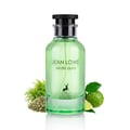 Maison Alhambra Jean Lowe Verde Aura — A green glass perfume bottle with a black cap, surrounded by fresh green grass, dried herbs, and a lime fruit. | Maison Alhambra Jean Lowe Verde Aura — Botol kaca hijau dengan penutup hitam, dikelilingi oleh rumput hijau segar, herba kering, dan buah limau.