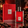 Karus Oud Fire by Khadlaj — Red textured box and red glass perfume bottle with silver ribbed cap, set against a dark marble surface with oud wood pieces and amber-like droplets, with a warm, smoky background.