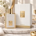 Karus Secret Musk by Khadlaj — White and gold ribbed perfume bottle and matching box displayed on a marble tray with white towels and flowers.