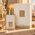 Karus Secret Musk by Khadlaj — White and gold perfume bottle and box set on a marble surface, with a blurred floral arrangement in the background.