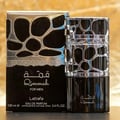 Lattafa Lattafa Qimmah Eau De Parfum for Men 100ml — Kotak dan botol minyak wangi hitam dengan reka bentuk perak berlubang yang unik, tulisan emas pada kotak dan botol.