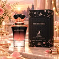 Maison Alhambra Mia Dolcezza by Maison Alhambra 100ml EDP Women — Elegant perfume bottle with gradient pink to black glass, ornate gold and black cap, displayed on a marble surface with a bouquet of pink roses, jewelry, and a lipstick.
