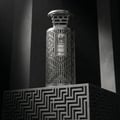 Zimaya Modhesh Noble 100ml by Zimaya — A silver perfume bottle with intricate geometric cutouts sits on a matching patterned pedestal against a dark, dramatic background. | Zimaya Modhesh Noble 100ml by Zimaya — Botol minyak wangi perak dengan potongan geometrik rumit terletak di atas alas bercorak yang sepadan dengan