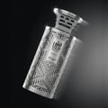 Zimaya Modhesh Noble 100ml by Zimaya — A silver, intricately patterned perfume bottle with a metallic cap, angled against a dark, gradient background with subtle lighting effects. | Zimaya Modhesh Noble 100ml by Zimaya — Botol minyak wangi berwarna perak dengan corak berukir rumit dan penutup logam, diletakkan condong