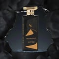 Gulf Orchid Moonlight Eau De Parfum 100ml by Gulf Orchid — A black perfume bottle with gold accents and a desert night scene on the label, displayed on a dark circular pedestal against a textured black background. | Gulf Orchid Moonlight Eau De Parfum 100ml by Gulf Orchid — Botol minyak wangi hitam dengan aksen emas