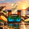Armaf Ombre Fresh by Armaf 100ml EDP Unisex — Ombre Fresh Parfum bottle with gold cap, set on rocks by the sea at sunset, with orange and lime slices