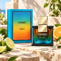 Armaf Ombre Fresh by Armaf 100ml EDP Unisex — A blue ombre box with gold lettering sits next to a glass perfume bottle with a gold cap, surrounded by limes, orange slices, and white blossoms.