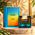 Armaf Ombre Fresh by Armaf 100ml EDP Unisex — Blue and gradient box next to a glass perfume bottle with gold cap, on a marble surface with palm leaves and shadows.