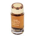 Ard Al Zaafaran Oud Al Turas 100ml by Ard Al Zaafaran — A clear glass bottle of amber-colored perfume with gold and bronze cap, featuring Arabic script and "OUD AL TURAS" text. | Ard Al Zaafaran Oud Al Turas 100ml oleh Ard Al Zaafaran — Botol kaca jernih berisi minyak wangi berwarna ambar dengan penutup emas dan