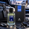 TADangel Pathway by Tad Angel 100ml EDP Men — A black leather duffel bag, car keys, and sunglasses are arranged around a glass perfume bottle and its black textured box, set against a blurred background of a cityscape and private jet.