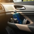 Afnan 9AM Dive by Afnan EDP 100 ml For Men — Botol wangian biru terang diletakkan di dalam poket pintu kereta bersama cermin mata hitam dan kunci kereta