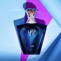 Afnan Turathi Blue by Afnan 90ml EDP for Man — Botol kaca biru gelap berbentuk unik dengan penutup berkilat keemasan, diletakkan di atas latar belakang biru dan ungu yang berlapis.