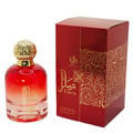 Al Wataniah Tiara — Botol kaca merah gradien dengan penutup emas bertekstur, diletakkan di sebelah kotak merah berhias emas. Terdapat tulisan Arab dan Inggeris.