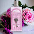 Ard Al Zaafaran Bab Al Wardi For Her — Pink perfume bottle with ornate silver key and floral background.