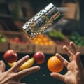 Ard Al Zaafaran Jazzab Silver — Perfume bottle suspended mid-air above hands catching fruit, with fruit crates in background.