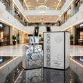 Armaf Club De Nuit Sillage — Silver geometric patterned bottle and box displayed on a reflective black surface in a mall.