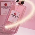 Grandeur Glitz Glam by Grandeur Elite 100 ml for Women — Pink glitter perfume bottle with gold accents and a swirling trail of golden sparkles