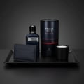 Grandeur Tribal Blue Man 100ml EDP Men — Dark blue perfume bottle, matching cylindrical box, black cardholder, and black candle on a black tray against a dark grey background.