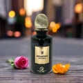 Grandeur Mountain Nuit Paris 100ml EDP Grandeur Elite for Men — Black perfume bottle with gold cap and label, on a wooden surface with a pink rose and orange flower petals