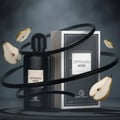 Optimum Noir by Grandeur – Botol dan kotak wangian hitam dengan hirisan pir dan reben hitam berlingkar berlatar belakang gelap berasap.