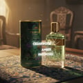 Grandeur Tribal Exotic by Grandeur 100ml EDP Men — A green patterned cylindrical box and a clear glass perfume bottle with a gold cap, set on a patterned fabric surface with ornate chairs in the background.