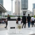 Lattafa Ana Abiyedh — White perfume box and clear bottle with gold accents on marble, city buildings in background