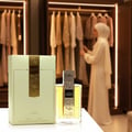 Lattafa Angham by Lattafa EDP 100ml Women — Perfume bottle and box with musical notes design, woman in white hijab selecting